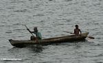 Father and son paddling in a dugout canoe near Loango, Gabon