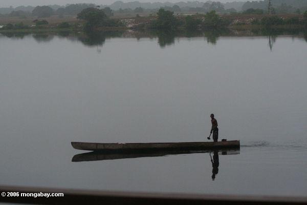 Pescador que rema perto do parque nacional de Loango