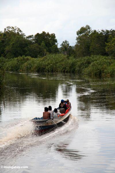 семьи, возглавляемые upriver в лодку с подвесным мотором