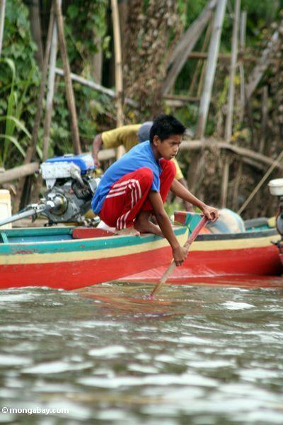 Junge, der ein traditionelles Boot nahe See Tempe Sulawesi