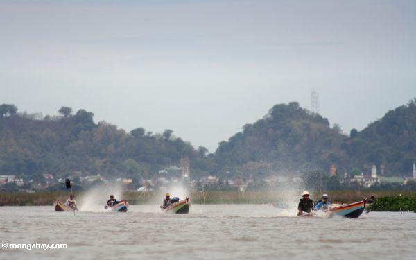 Die Männer, die in traditionelles Buginese sich nähern, motorisierten Kanus auf See Tempe