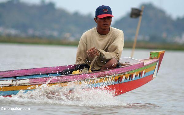 Mann in traditionellem Buginese motorisierte Boot auf See Tempe