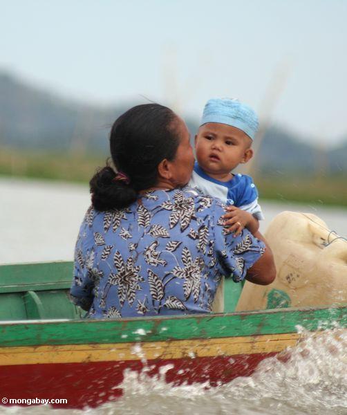 Frau mit Baby in traditionellem Buginese motorisierte Boot