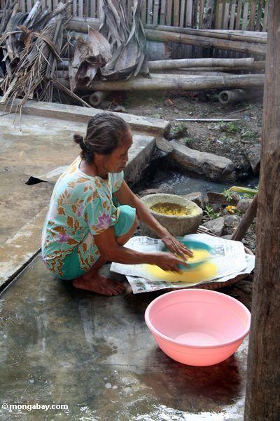 Frau, die mit dem Material benutzt für färbendes silk gelbes Sulawesi