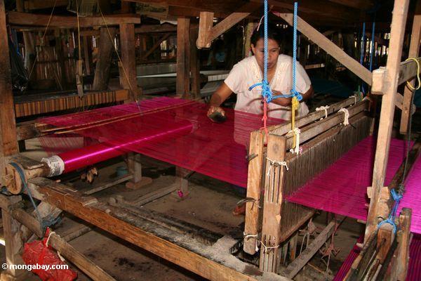 Magenta-rote Seide, die gearbeitet wird von der Frau in Sengkang
