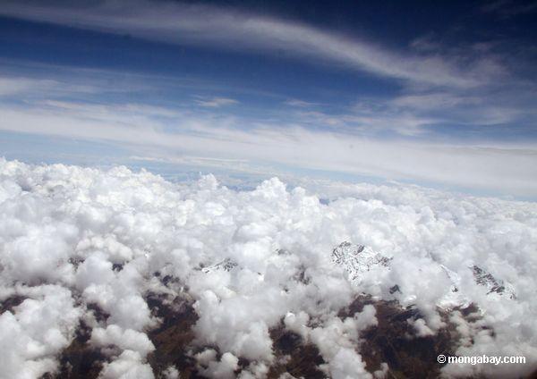 Andengebirgsspitzen, die durch Wolken Peru