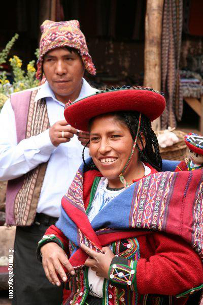 Mulher de Quencha que desgasta a roupa tradicional no mercado de Chinchero