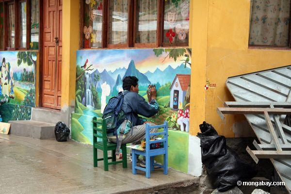 Straße Maler, der auf Erhaltung Wandbild arbeitet.