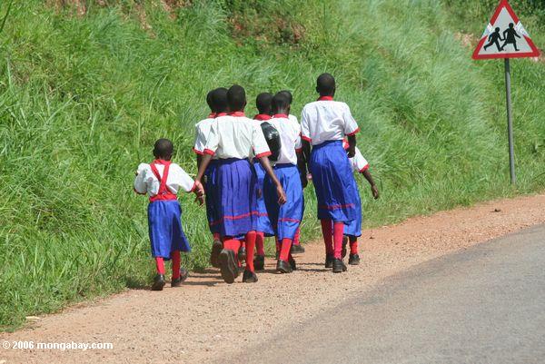 Kinder, die entlang eine Landstraße in Uganda Uganda