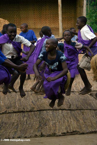 Crianças de Bwindi, muitas de quem são orphans do AIDS, executando canções e danças tradicionais