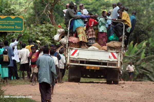 Leute gehen voran, um in der Rückseite eines LKW Uganda