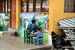 Street painter working on conservation mural.