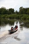 Family headed upriver in boat with outboard motor (Kalimantan, Borneo (Indonesian Borneo)) 