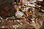 1000 rupiah note among cigarettes and coins at grave site in cave (Toraja Land (Torajaland), Sulawesi) 