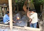 Metal workers hammering a machete into shape (Toraja Land (Torajaland), Sulawesi) 