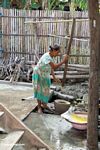 Woman working with yellow dye used with silk (Sulawesi (Celebes))